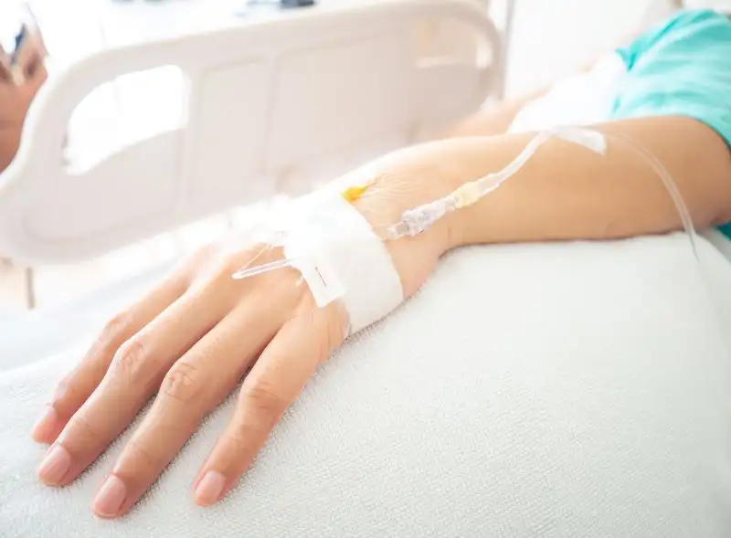 Hand mit einem Tropf an der Infusion