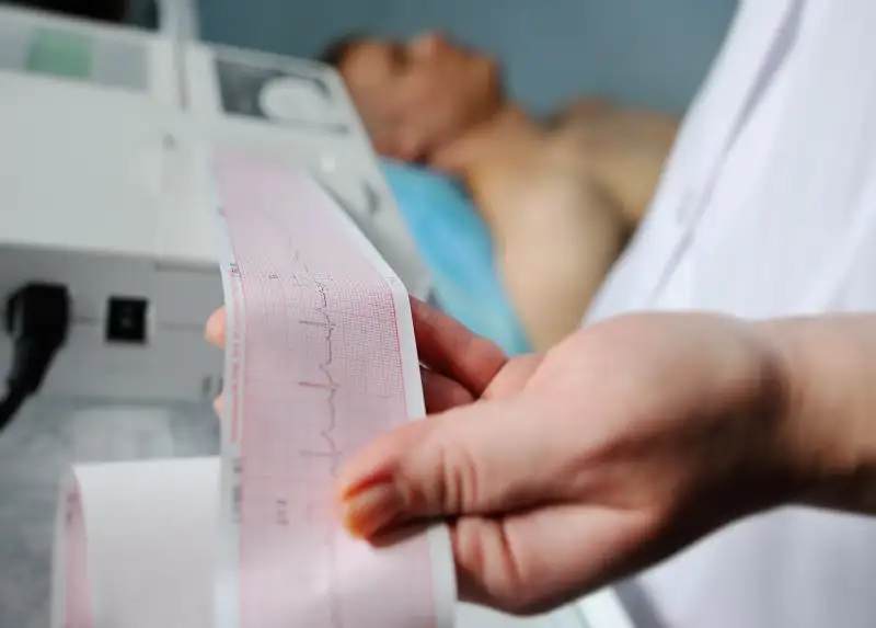 Eine medizinische Fachkraft analysiert einen EKG-Ausdruck