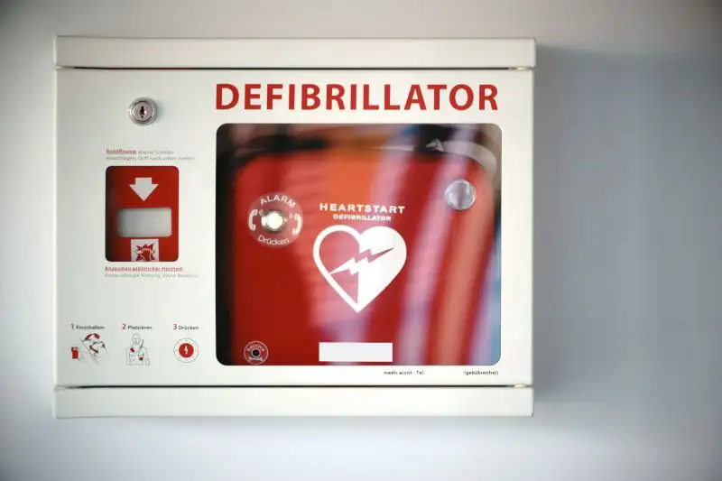 Wandmontierter Defibrillator in einem weißen Gehäuse